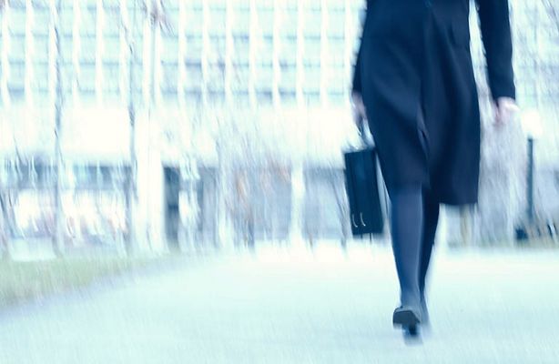 Blur of businesswoman walking along path in park.jpg