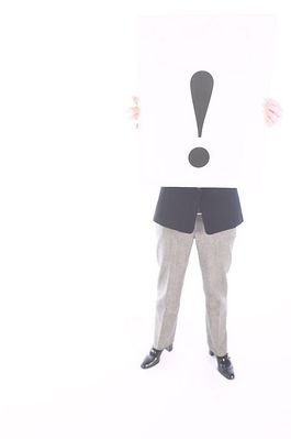 Businesswoman holding white sign with exclamation mark.jpg