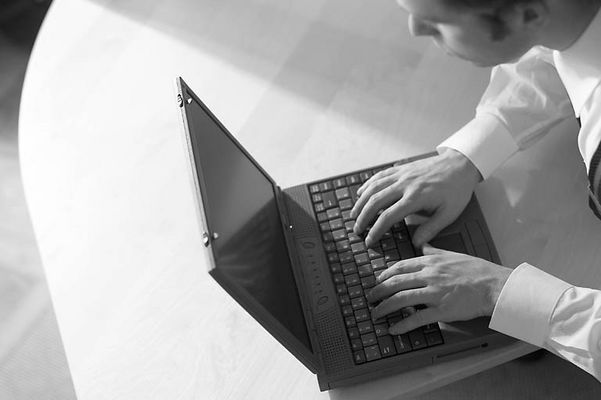 Caucasian businessman typing on black laptop computer.jpg