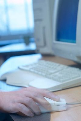 Caucasian man hand operating mouse on desk beside computer.jpg