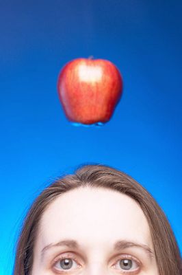 Caucasian woman face with apple hanging over her head against 2.jpg