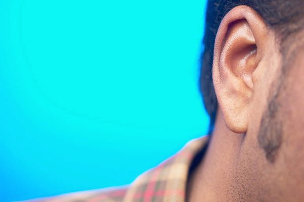 Close up of South Asian man ear against blue background.jpg