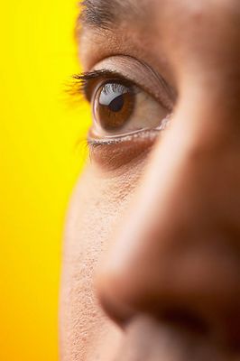 Close up of half of South Asian man face against yellow backgr 3.jpg