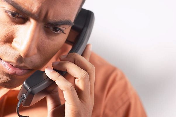 Frowning man talking on telephone.jpg