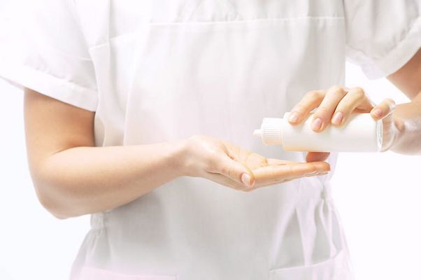 Masseuse pouring massage oil in her hands 1.jpg