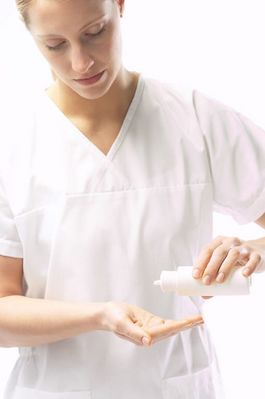 Masseuse pouring massage oil in her hands 2.jpg