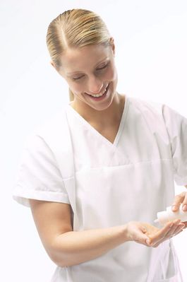 Masseuse pouring massage oil in her hands.jpg