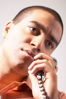 Perplexed man talking on telephone.jpg