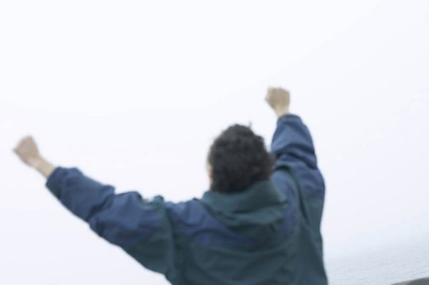 Person in blue raincoat cheering to sky.jpg