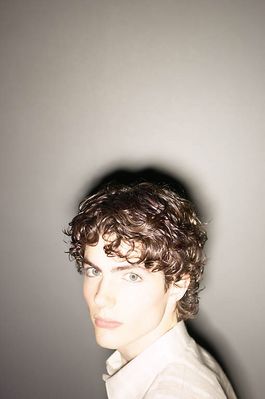 Teenaged boy against wall with shining light.jpg
