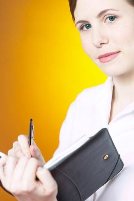 Thoughtful businesswoman writing in day planner.jpg