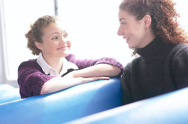 Two smiling women sitting in blue vinyl seats.jpg