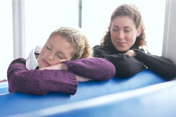 Two women sitting in blue vinyl seats uid 1283657.jpg
