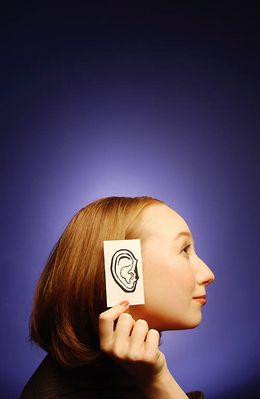 Woman holding paper ear to the side of her head 3.jpg