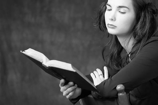 Woman reading book in wooden chair 1.jpg