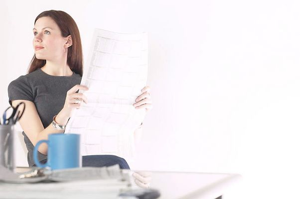 Woman reading newspaper at her desk 5.jpg
