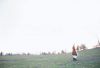 Businessman walking through field with briefcase and newspaper.jpg