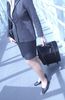Businesswoman with luggage in glass hallway uid 1284384.jpg