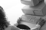 Caucasian businesswoman typing at desk in front of computer.jpg