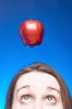 Caucasian woman face with apple hanging over her head against 1.jpg