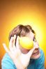 Caucasian woman holding yellow lemon up to face against yellow b.jpg