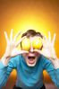 Caucasian woman holding yellow lemons to eyes against yellow bac 1.jpg