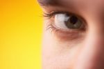Close up of Caucasian man brown eye against yellow background.jpg