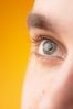 Close up of Caucasian man green eye against yellow background 1.jpg
