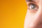 Close up of Caucasian man green eye against yellow background 2.jpg
