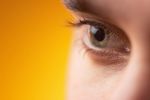 Close up of Caucasian man green eye against yellow background 3.jpg