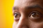Close up of South Asian man brown eyes against yellow backgrou.jpg