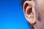 Close up of South Asian man ear against blue background 1.jpg