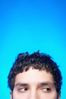 Hispanic man looking sideways against blue background.jpg