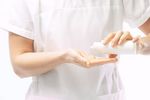 Masseuse pouring massage oil in her hands 1.jpg