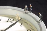 Models of businessmen walking along clock.jpg