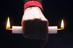 Person holding candle burning at both ends 1.jpg