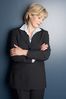 Smiling businesswoman leaning against wall.jpg