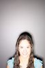 Smiling teenaged girl standing against gray wall 1.jpg