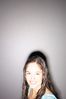 Smiling teenaged girl standing against gray wall 2.jpg
