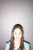 Smiling teenaged girl standing against gray wall.jpg