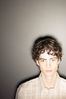 Teenaged boy against gray wall 1.jpg