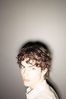 Teenaged boy against wall with shining light.jpg