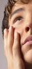 Teenaged boy looking up with his hand on his face.jpg