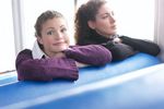 Two women sitting in blue vinyl seats.jpg