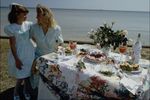 Woman and girl standing next to dinner table on be.jpg