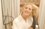 Woman blow drying her hair in bathroom mirror.jpg
