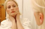 Woman looking at her face in bathroom mirror 1.jpg