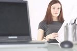 Woman reading newspaper at her desk 1.jpg