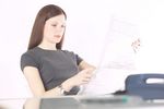 Woman reading newspaper at her desk 2.jpg